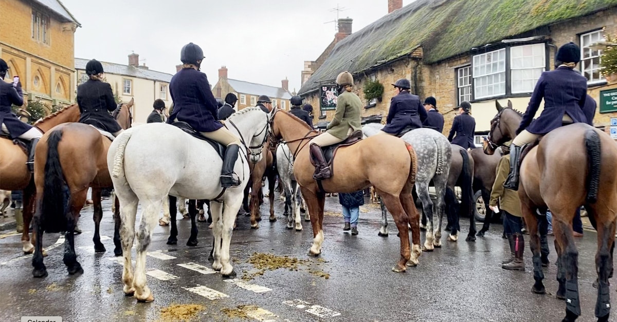 Mounted field riders with the Blackmore and Sparkford Vale Hunt gather in a town centre.