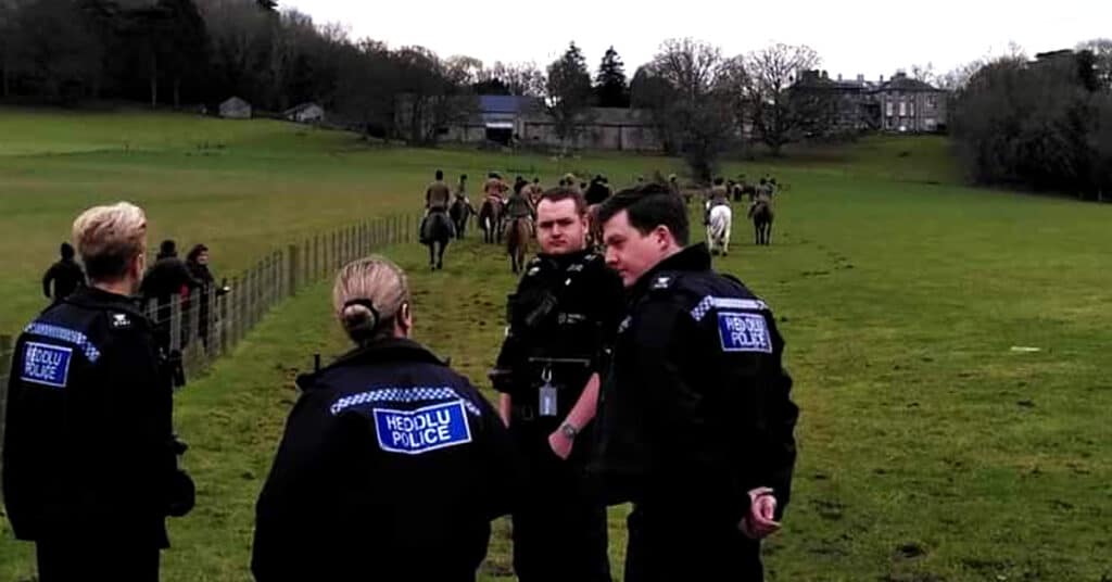 North Wales Police officers standing in front of riders with the Flint and Denbigh Hunt